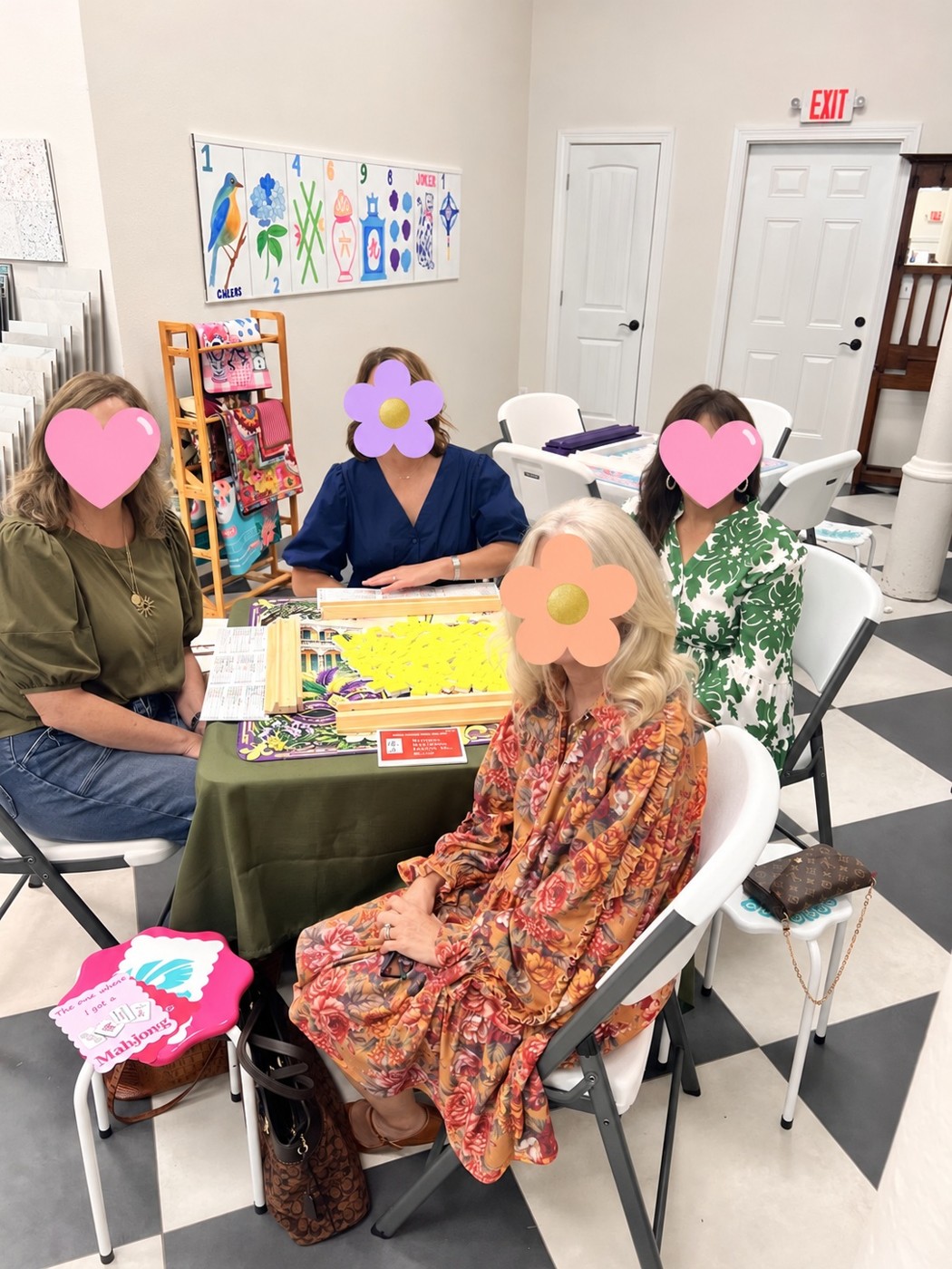 Four players gathering around a mahjong table, faces covered with hearts and flowers